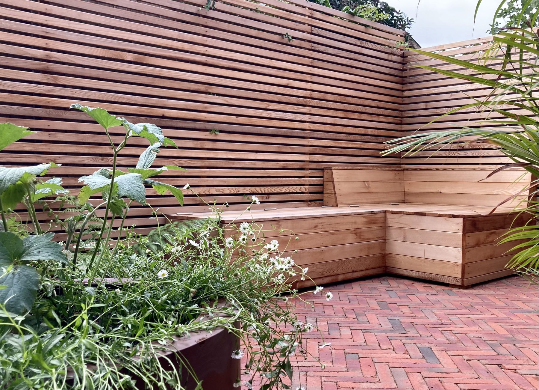 East Dulwich garden with cedar bench, slatted fencing and herringbone clay paving