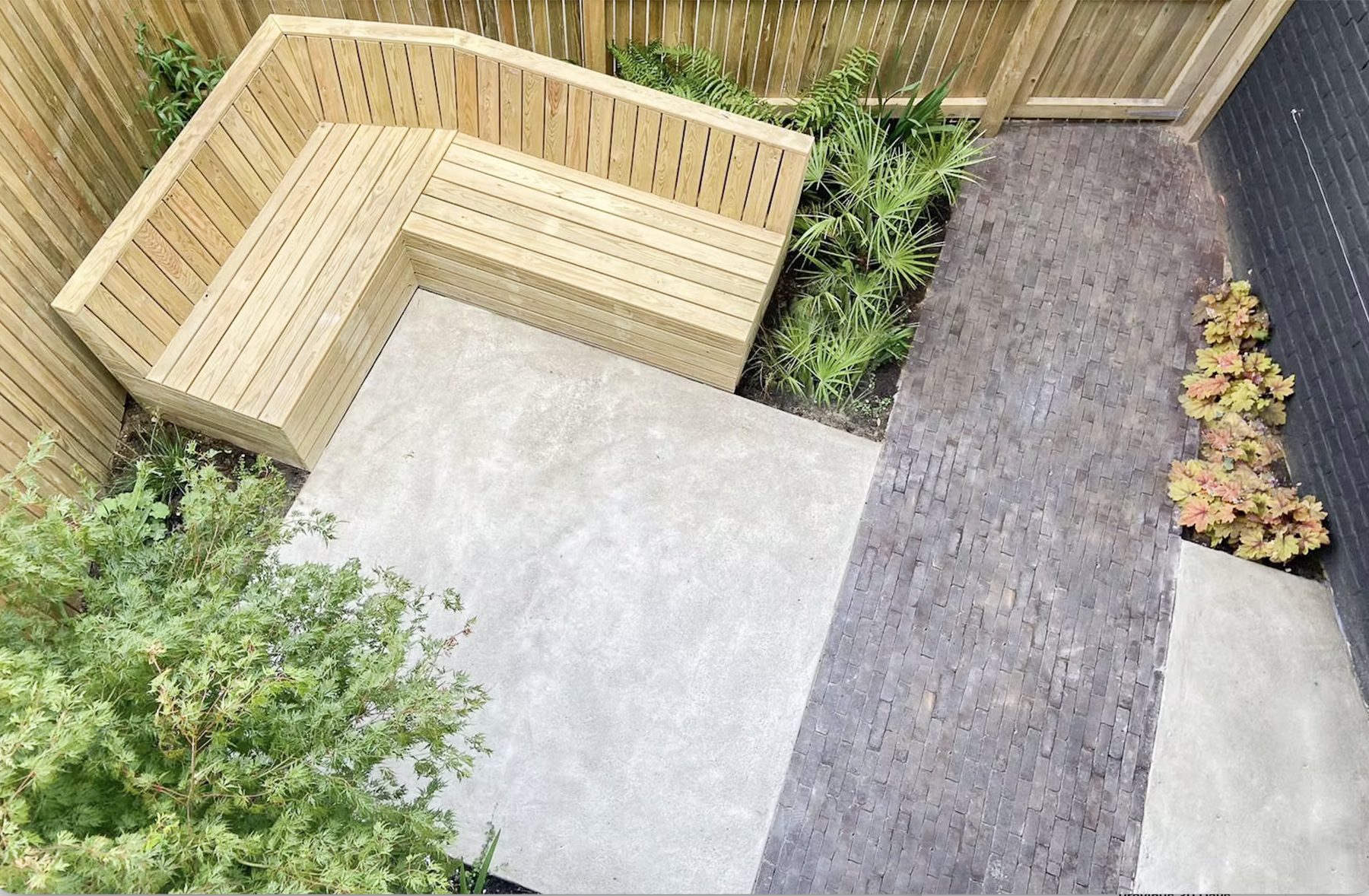 Overhead view of built-in seating, palms, brick path and concrete pads in Tulse Hill